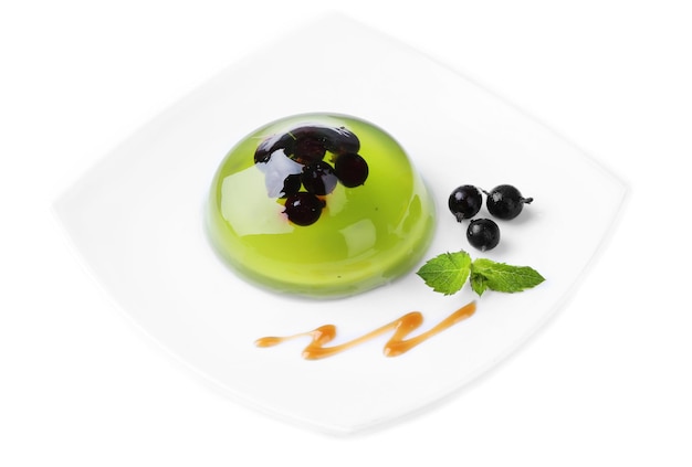 Green jelly with blackcurrant berries and sauce isolated on white