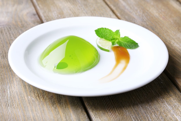 Green jelly with mint leaves on wooden table