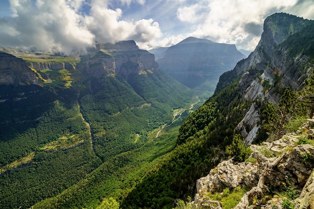 Green landscape in the Pyrenees of the Ordesa and Monte Perdido valley with mountains, rocks, forests and sky with clouds. Top aerial view.