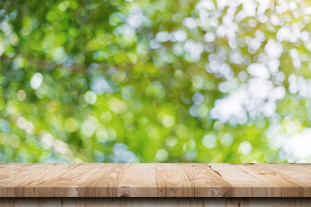 Green leaf bokeh blurred and wood table for nature background