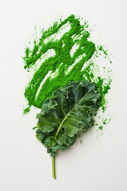 Green leaf of kale and kale powder on white background