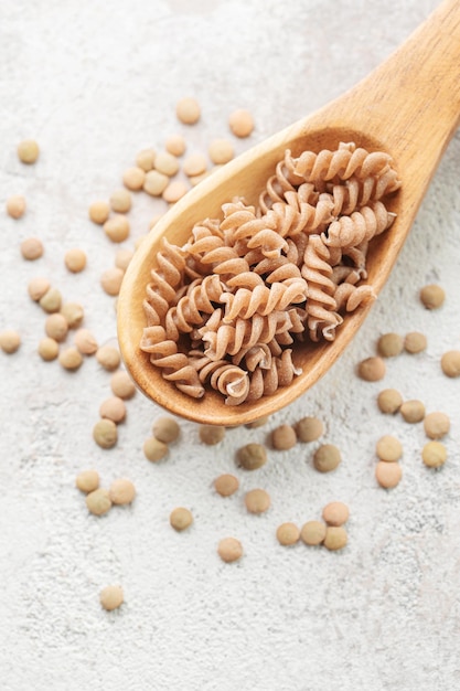 Green lentil fusilli pasta on a gray concrete background