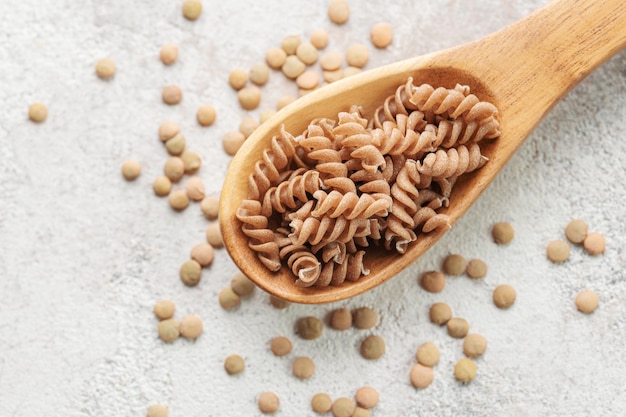 Green lentil fusilli pasta on a gray concrete background