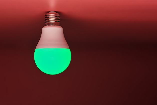 Green light bulb, modern energy saving, copy space. Minimal idea concept.