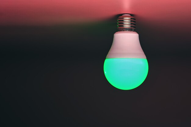 Green light bulb, modern energy saving, copy space. Minimal idea concept.