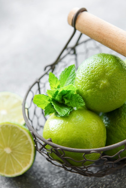 Green Limes with fresh mint leaves in basket