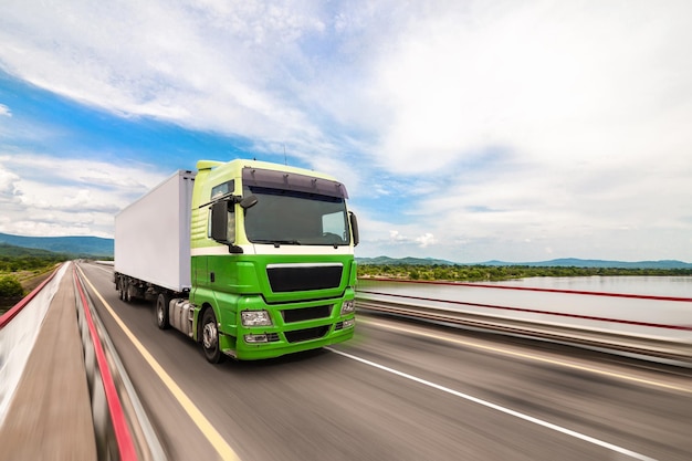 Green Man truck moving by a bridge