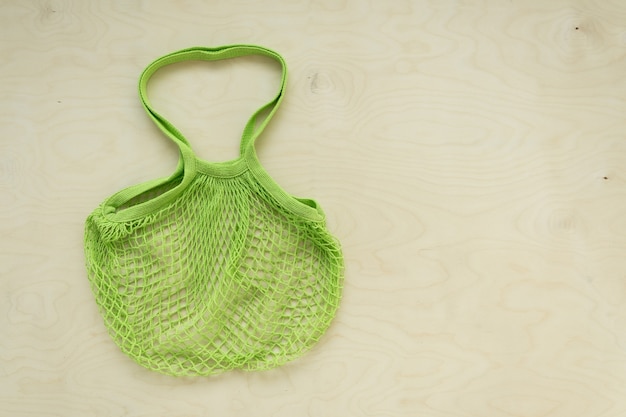 Green mesh tote bag on wooden background tote bag on wooden background with copy space flat lay top ...