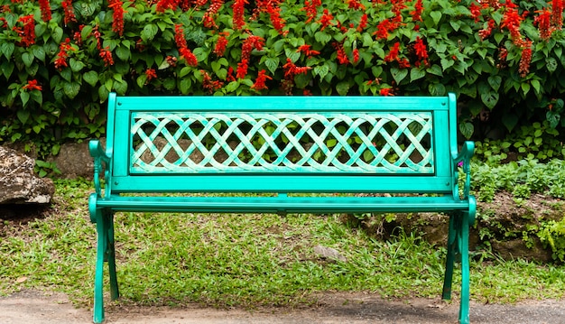 Green metal bench in the park. Relaxing with plant and tree