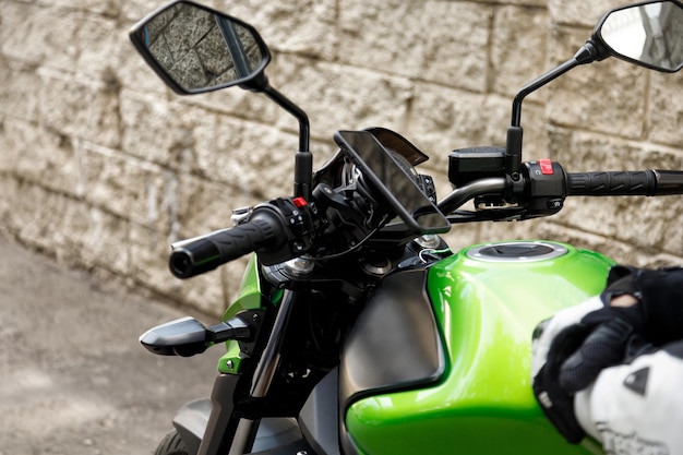 Green motorcycle is near the wall in the city Motorcycle mobile phone mount holder