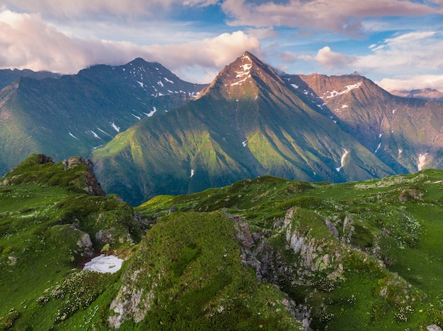 Green mountain peak. Layers of mountains in the haze during sunset. Krasnaya Polyana, Sochi, Russia.