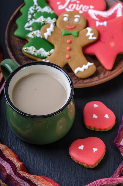 Green mug with hot chocolatend multi-colored gingerbread