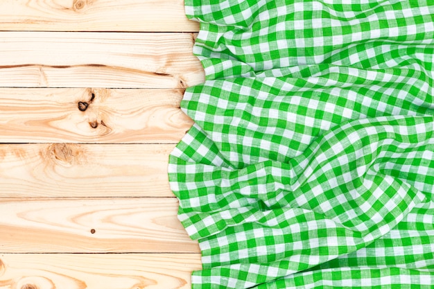 Green napkin on wooden table, top view