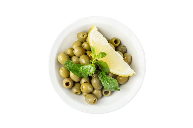 Green olives with lemon in a white bowl Traditional mediterranean appetizer Top view Closeup Isolated on white background