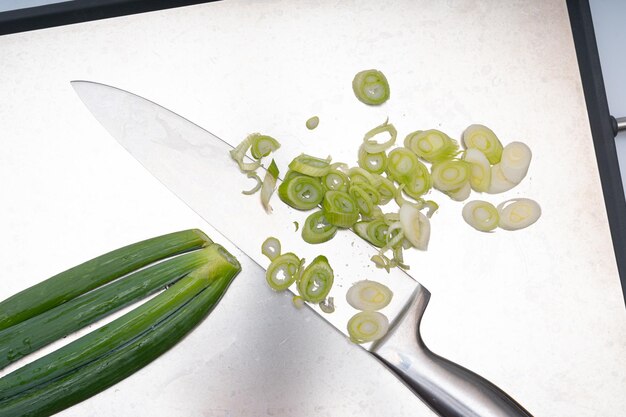 Green onion being trimmed on a white background