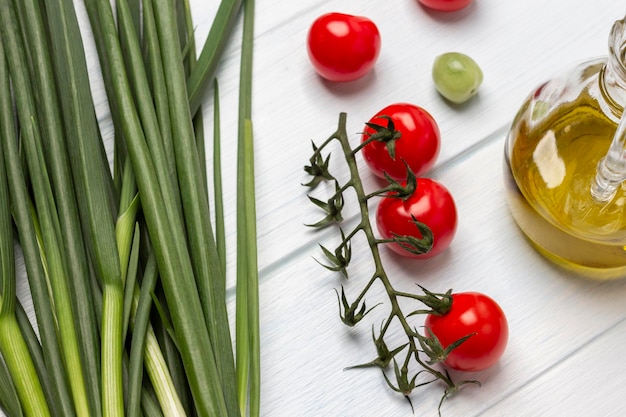 Green onion tomato branch and bottle of olive oil