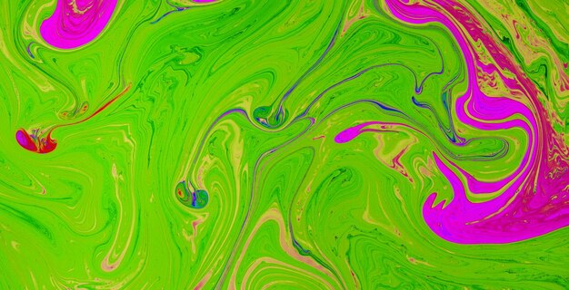 Green paint on a black background with a pink and green swirls.