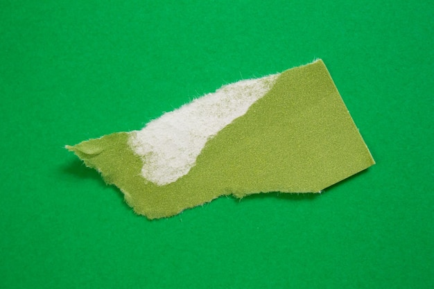 Green paper with a torn edge on a green background