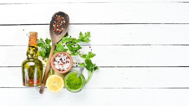 Green parsley sauce Ingredients for chimichurri sauce On a white wooden background Top view free space for your text