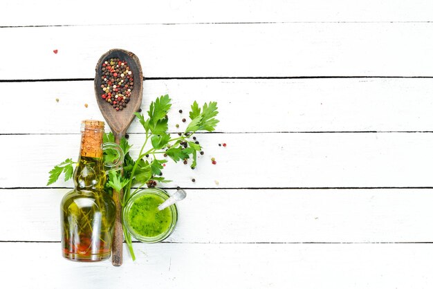 Green parsley sauce Ingredients for chimichurri sauce On a white wooden background Top view free space for your text