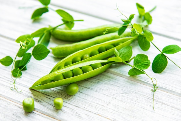 Green peas  on a white wooden table.  Healthy food