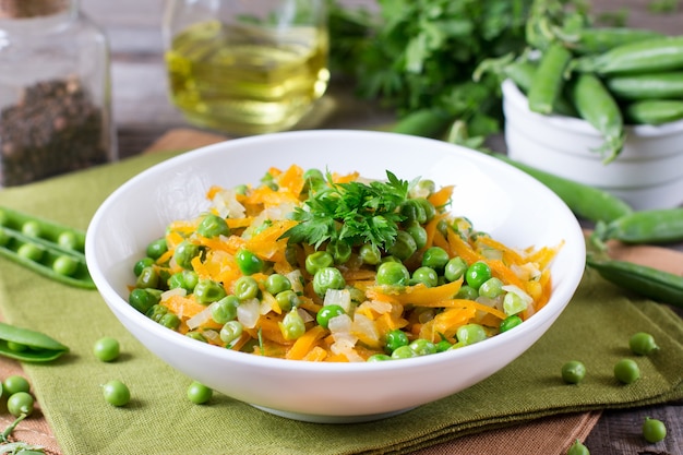 Green peas with carrots and onions on a plate