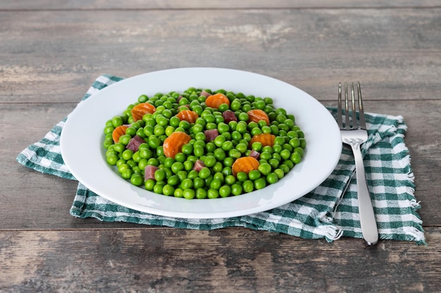 Photo green peas with serrano ham and carrot