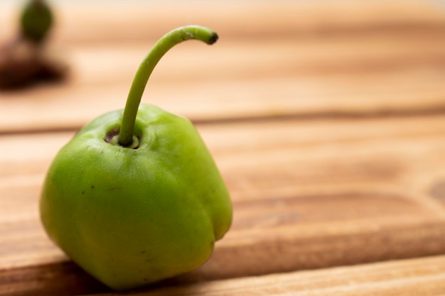 Photo a green pepper on a wooden table