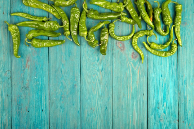 Green pepperoni peppers on the wooden table