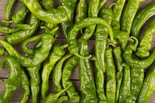 Green pepperoni peppers on the wooden table