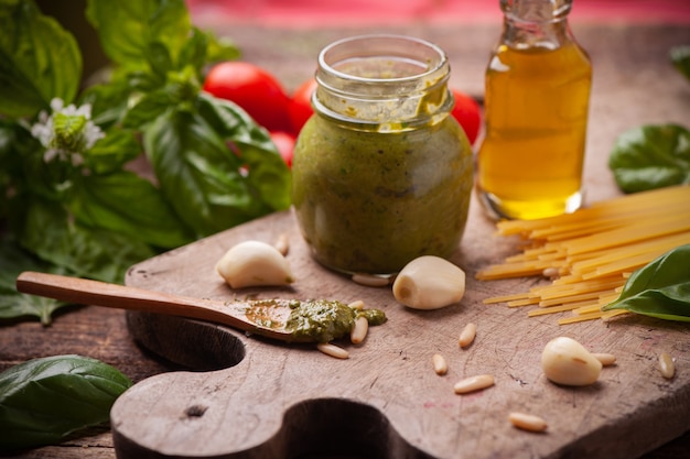 Green pesto in a jar with fresh basil