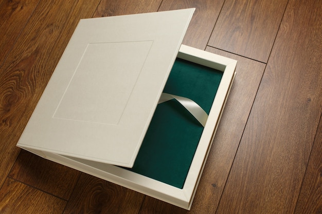 green photo book with textile cover in beige box with ribbon beautiful cardboard box for photo album