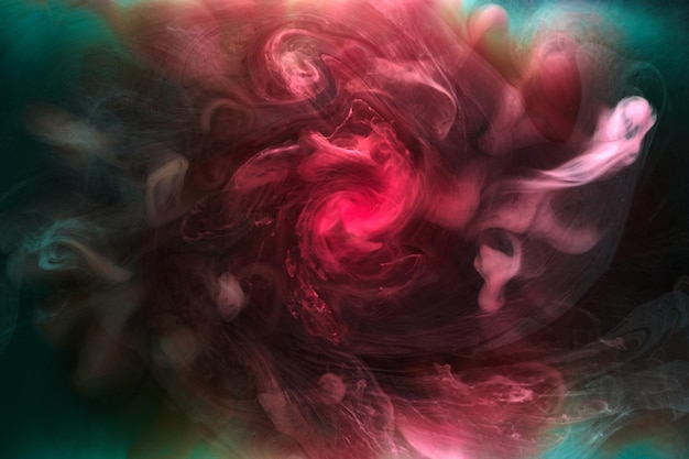 Green pink smoke on black ink background colorful fog abstract swirling touch ocean sea acrylic paint pigment underwater