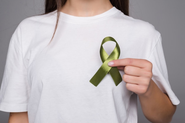 Green Ribbon a Symbol of Kidney Cancer isolated on gray wall