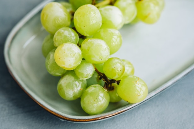 Green ripe grape on a plate, close-up.