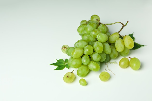 Green ripe grape with leaves on white background