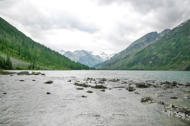 Green rocks and big clouds and river