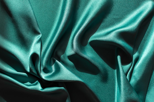 Green satin fabric pleats closeup Abstract trend background of the 2021 Tidewater Green color