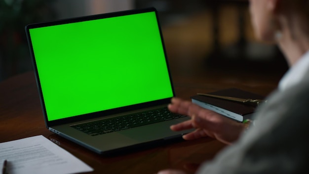 Green screen laptop with unknown senior woman having video call at home Elderly woman talking online at mockup computer indoors Unrecognizable old lady making conference at chroma key laptop