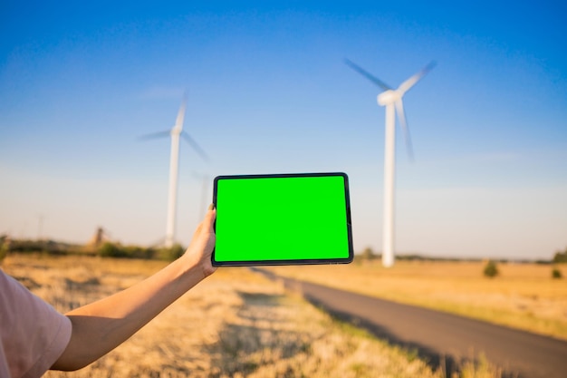 Green screen tablet on the windmills background. Chroma key. windmills green energy