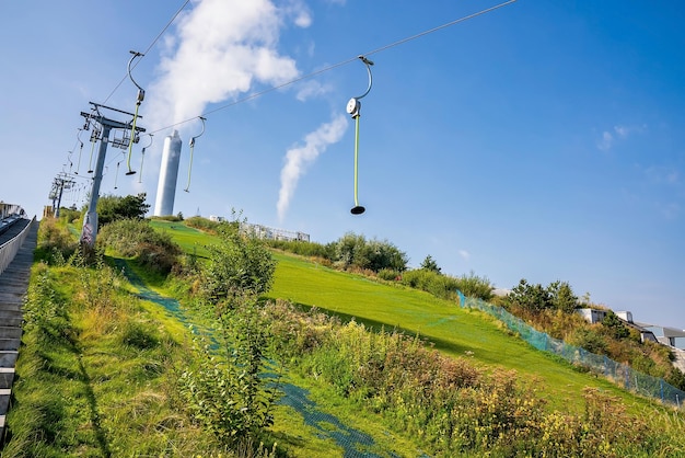 Green ski slopes with slides and kickers on top of the Amager Bakke, Copenhill Waste-to-Energy Power Plant in Copenhagen, Denmark