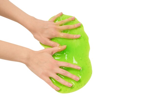 Green slime toy in woman hand isolated on white surface.