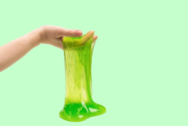 Green slime toy in woman hand isolated on white