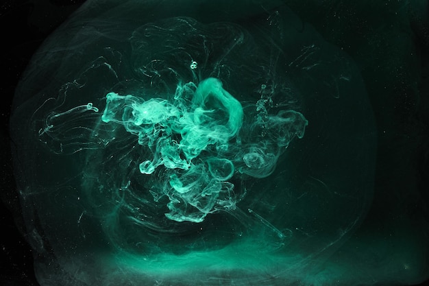 Green smoke on black ink background, colorful fog, abstract swirling emerald ocean sea, acrylic paint pigment underwater