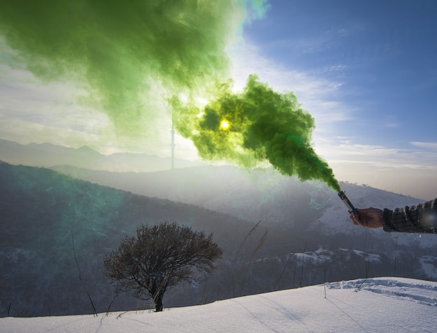 green smoke bomb in hand