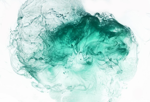 Green smoke on white ink background colorful fog abstract swirling emerald ocean sea acrylic paint pigment underwater