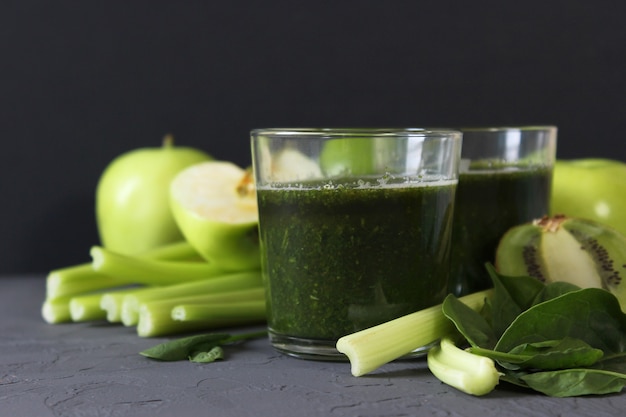 Green smoothie and fresh vegetables on the table for the detox organism