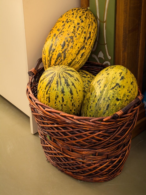 Green speckled melons in a straw basket