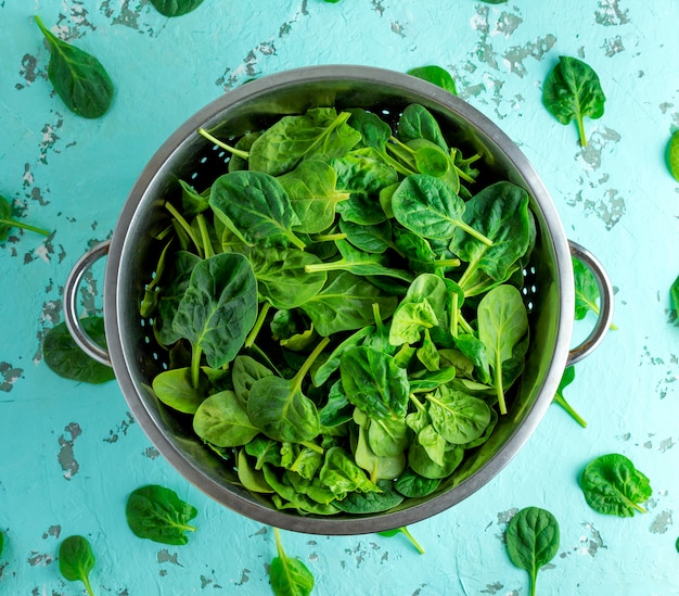 Green spinach leaves in an iron colander