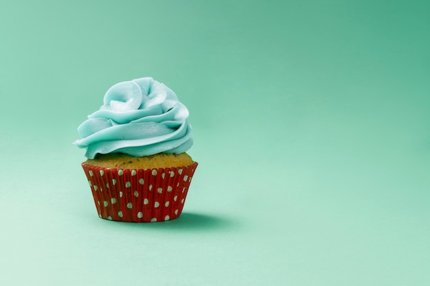 Green surface with tasty cupcake